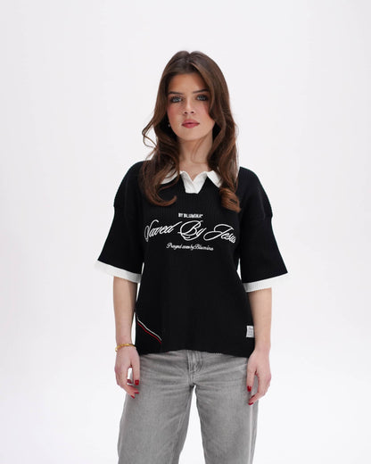 Woman wearing a black oversized t-shirt with white collar and text on a white background