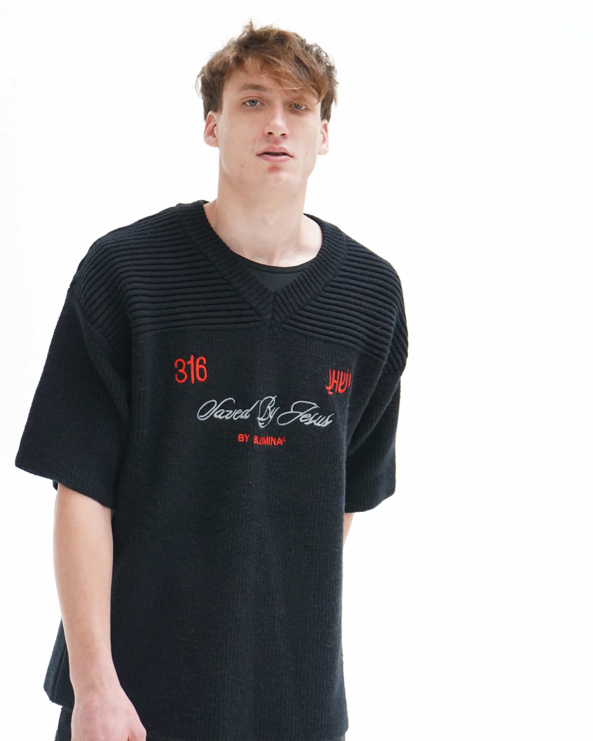 Person wearing a black sweater with red and white text on a white background